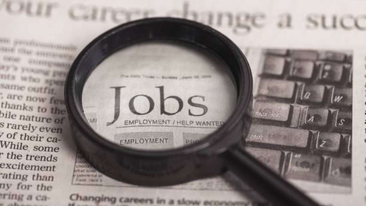 magnifying glass over the word "jobs" in a newspaper