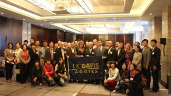 Group of Aggies holding up UC Davis flag 