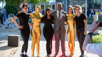 Chancellor Gary May poses for a photo on the red carpet with student performers.