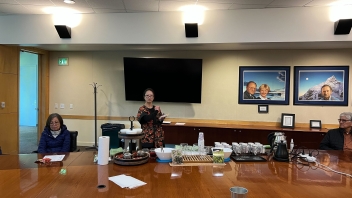 A group of people gathered around the conference room table at the Founders Board Room at the Alumni Center for a tea tasting and demonstration.