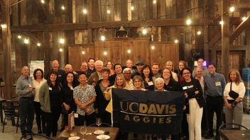 Group photo of attendees holding up the uc davis flag.