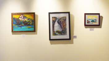 A trio of framed watercolor paintings hanging on a wall.