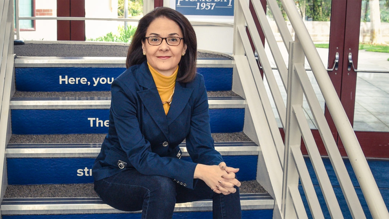 Dana Allen sitting on steps at Walter A. Buehler Alumni Center at UC Davis