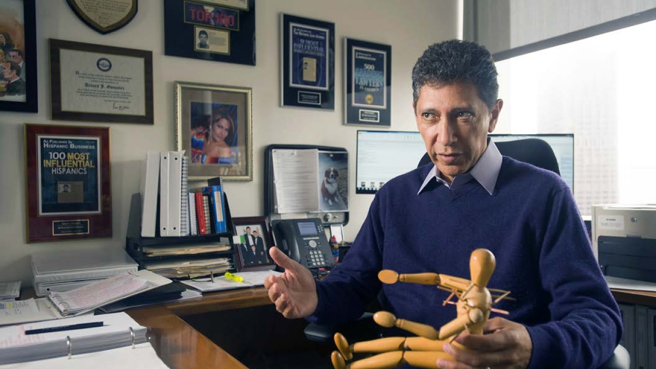 González demonstrates how he used a mannequin as an exhibit in his $12.5 million police excessive force case, earning the family of the victim the largest amount ever awarded for a police shooting in California. Arturo Gonzalez sitting at a desk