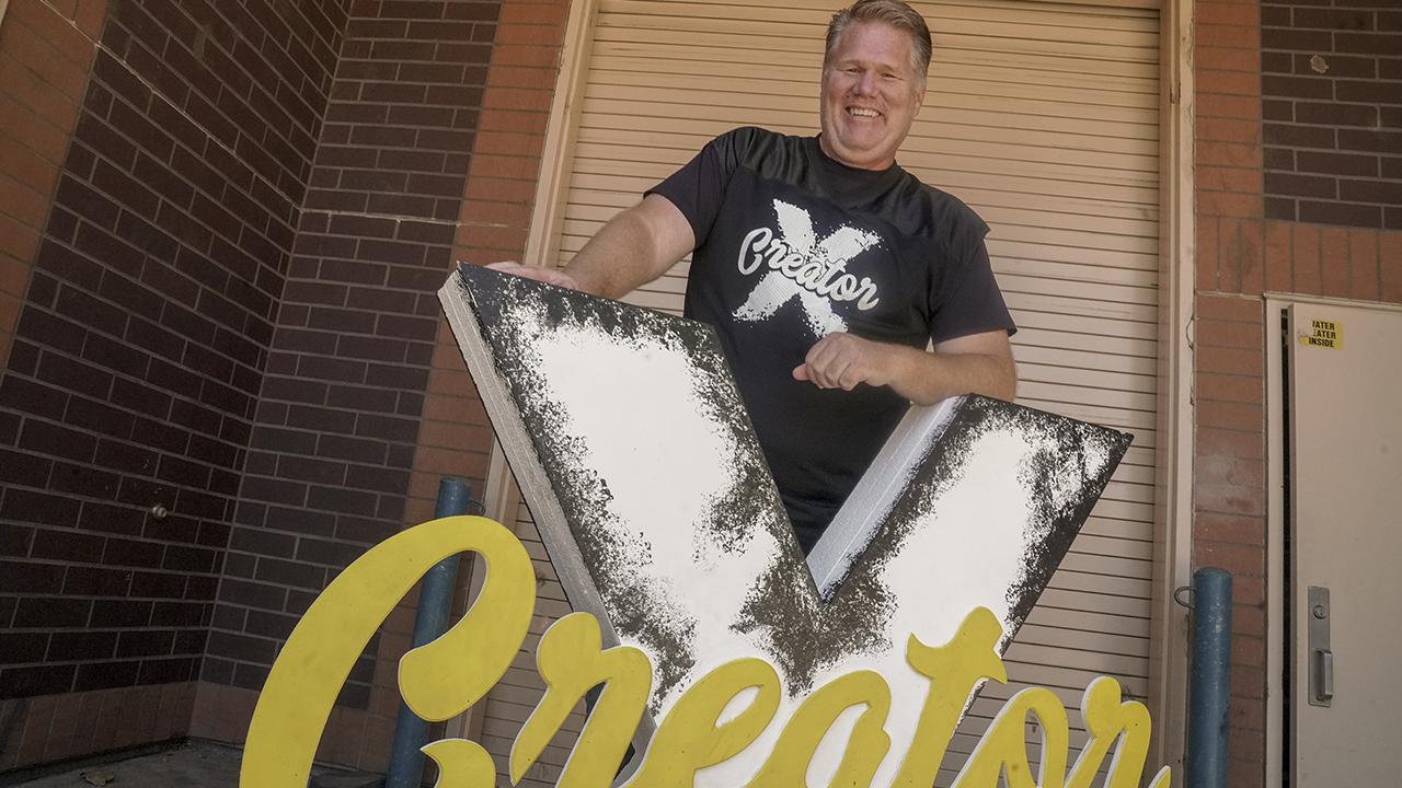 Shawn Sullivan standing with a Creator X sign