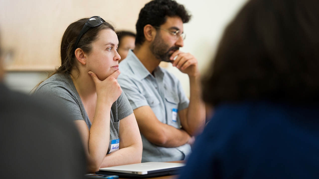 Two people sitting at a table, looking as though they're lost in thought.