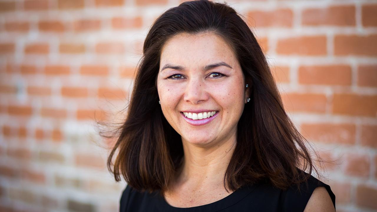 “UC Davis gave me so much in terms of my education and longtime friendships. It helped to form the mold in terms of who I am today,” said Heidi Jannenga, an alumna from the College of Biological Sciences. Heidi Jannenga with brick wall behind her