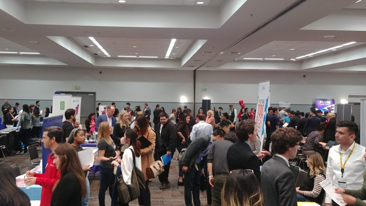 crowd of people at talking to representatives at company tables