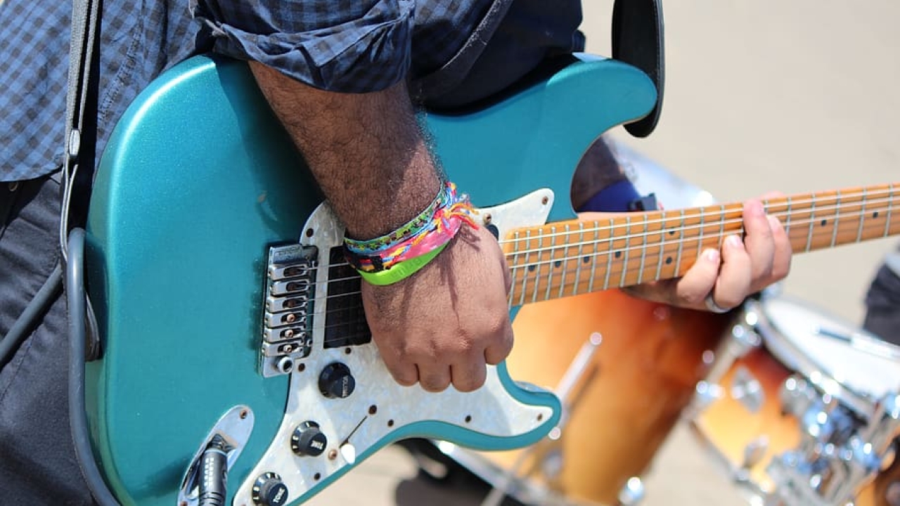 person playing a blue guitar