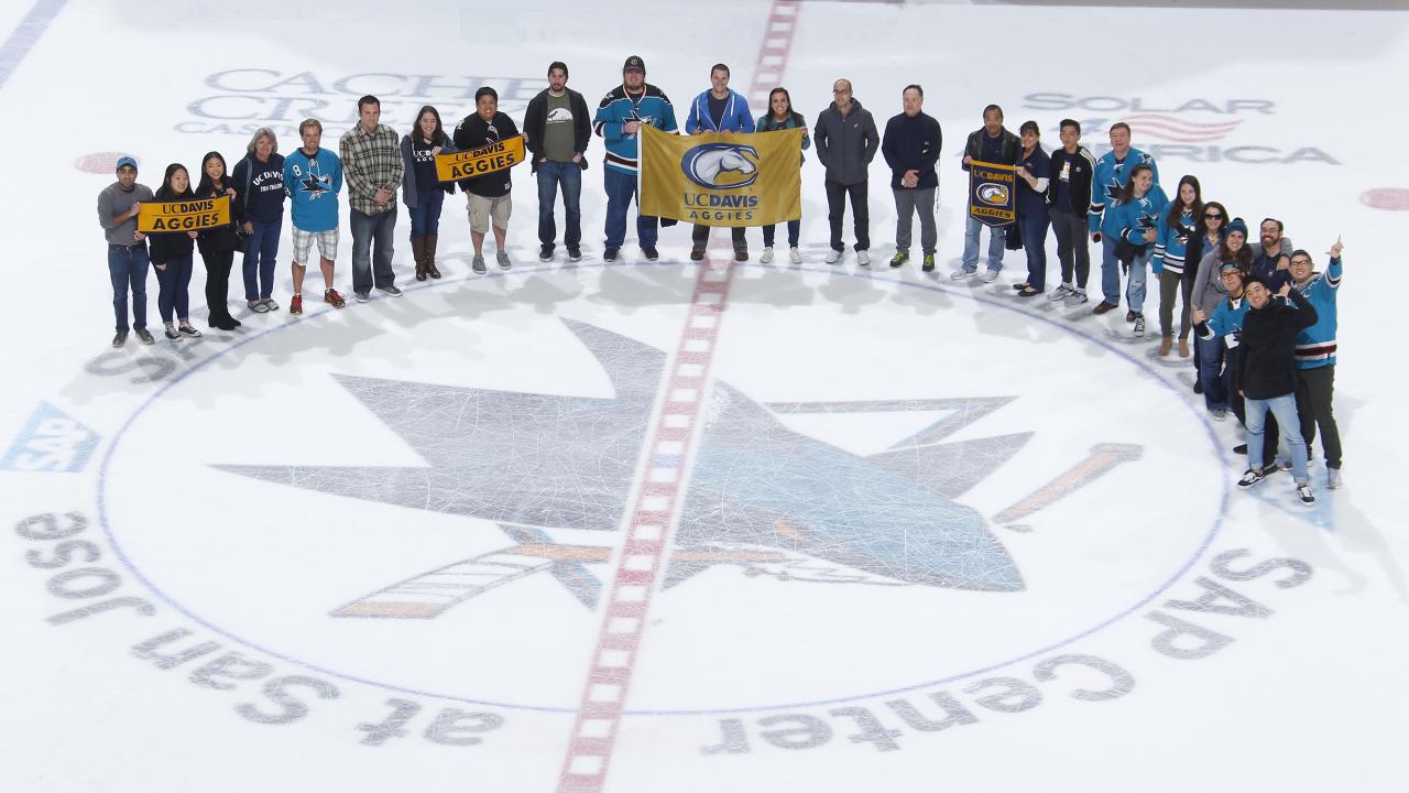 Group of alumni and friends on the Sharks ice after the game