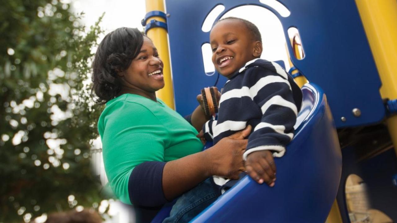 Picture of a women and a boy playing on a slide.