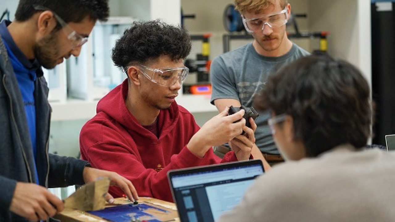 A group of students working on a project photographed in the Diane Bryant Engineering Student Design Center.