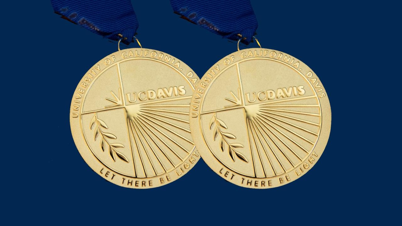 2 UC Davis Medals (gold) on UC Davis blue background