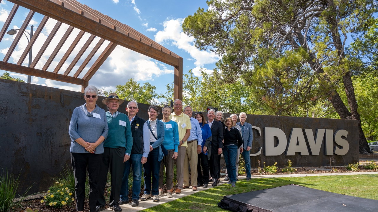 Group of alumni from class of 1968 standing next to new gateway structure.