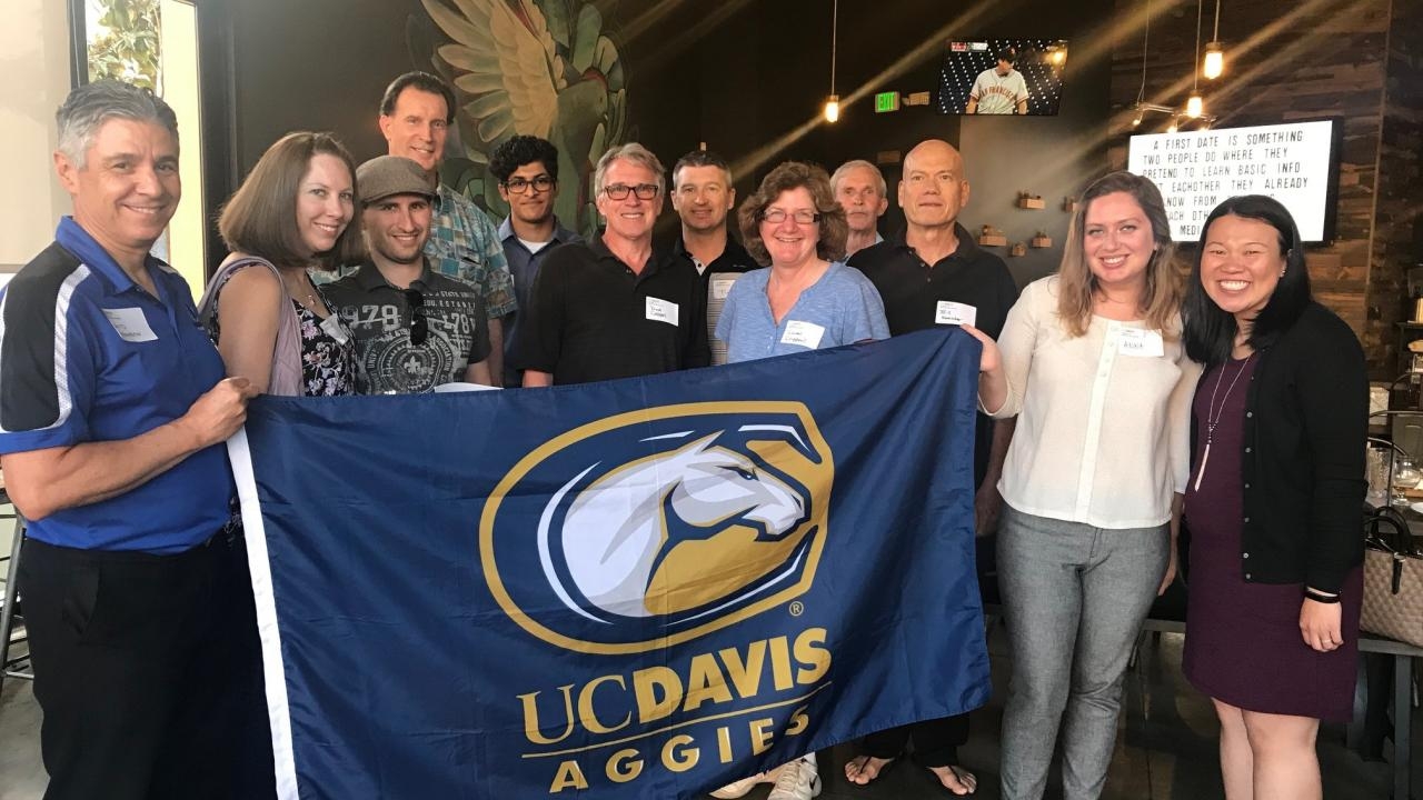 Alumni holding a UC Davis flag