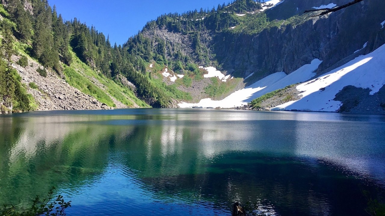 serene lake with mountains and trees off in the distance