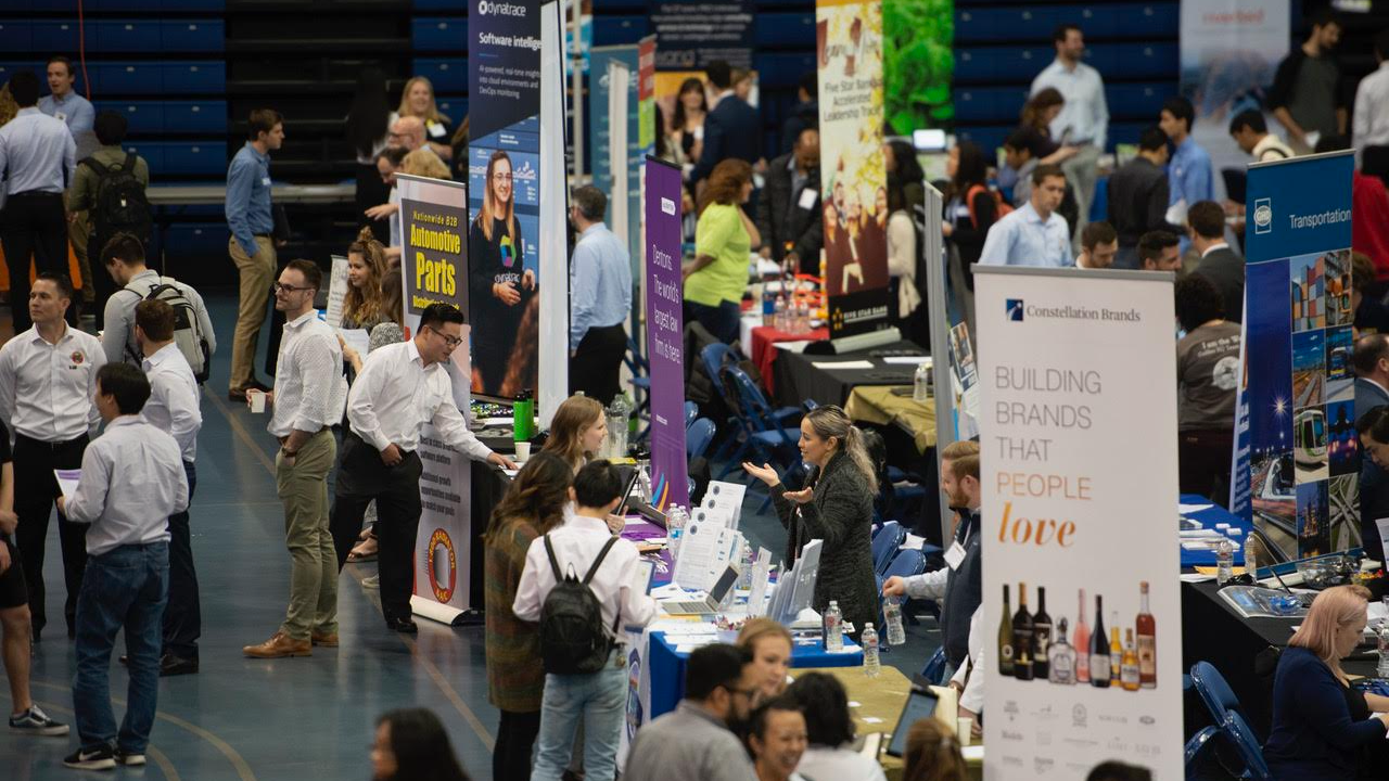 students standing at booths at a career fair
