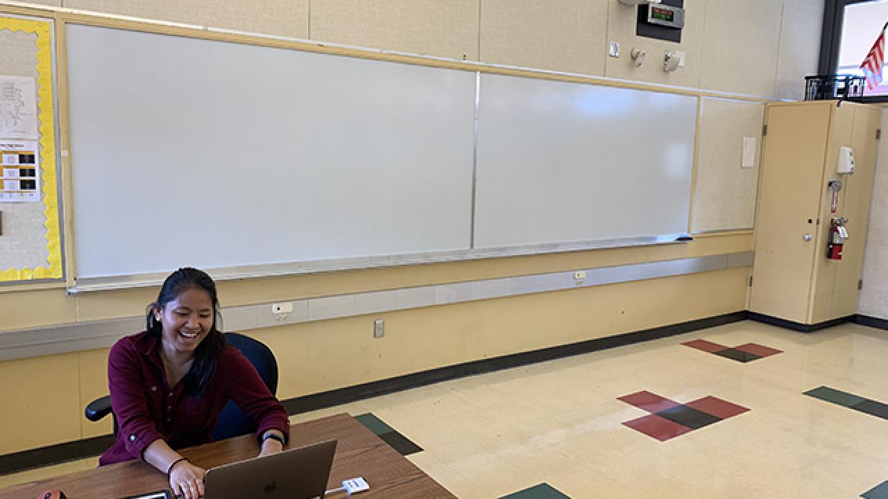 Person in a classroom sitting in front of a computer