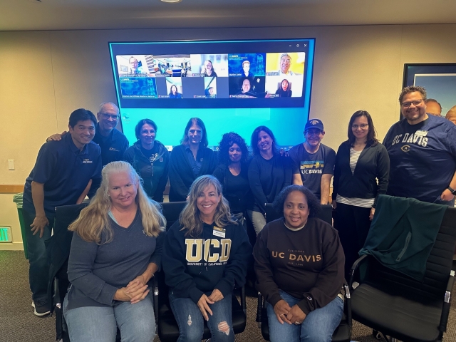 A group of Aggie Parent Family Council members pose in a meeting room.
