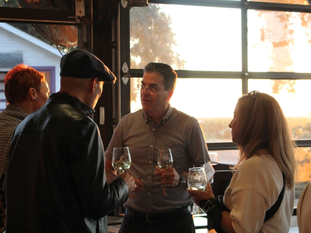Aggie Uncorked members chatting with wine at the Heringer Estate