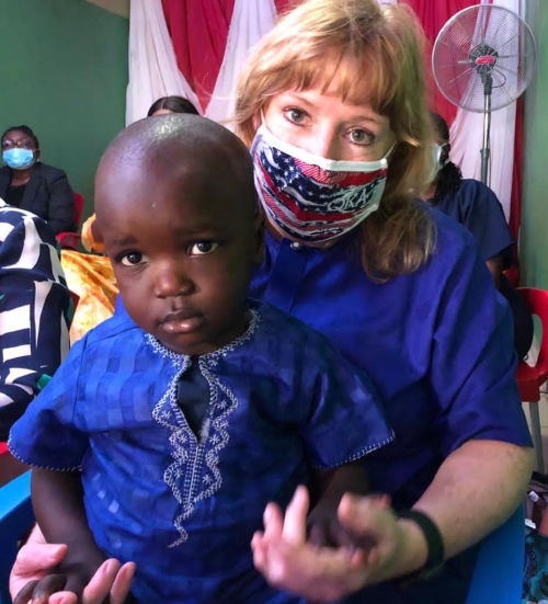 U.S. Ambassador Kathleen FitzGibbon poses with a young boy in Nigeria. 