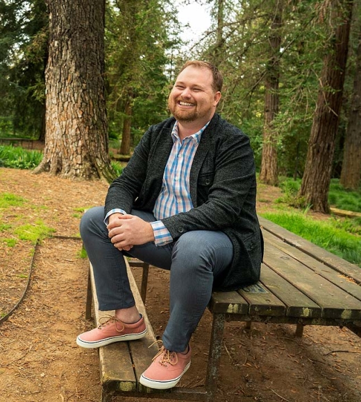 Paul Terry sitting on a bench in the arboretum.