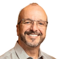 Headshot of Michael Coffey wearing glasses and a tan button-down shirt.