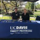 Two people sitting at a table with a sign that says UC Davis Parents Program