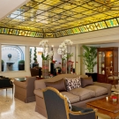 photo of hotel lobby with stained glass tiles towards the ceiling and seating in the middle of the image