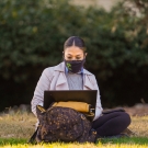 image of a student with a facemask using a laptop outside