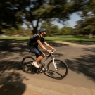 student riding on a bike on campus