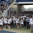 UC Davis students running onto the Aggie football field