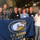 Alumni holding a UC Davis flag