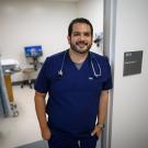 Matthew Vega standing outside a patient room in a medical setting