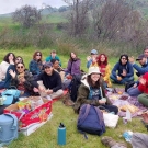 Group enjoying picnic on blankets in grassy hillside