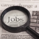magnifying glass over the word "jobs" in a newspaper