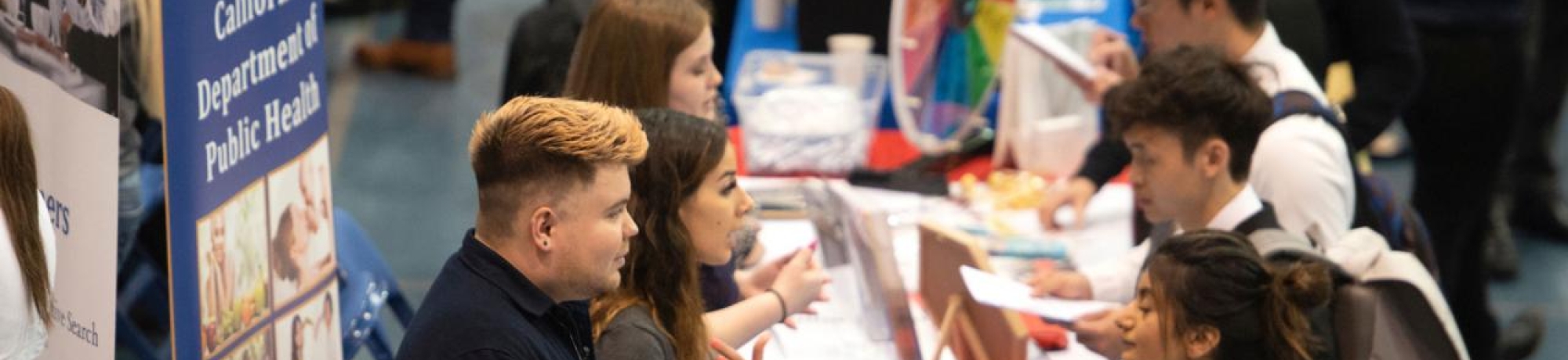People interacting at a career fair, pre-pandemic