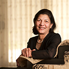 Mohini Jain sitting in a chair, smiling at camera